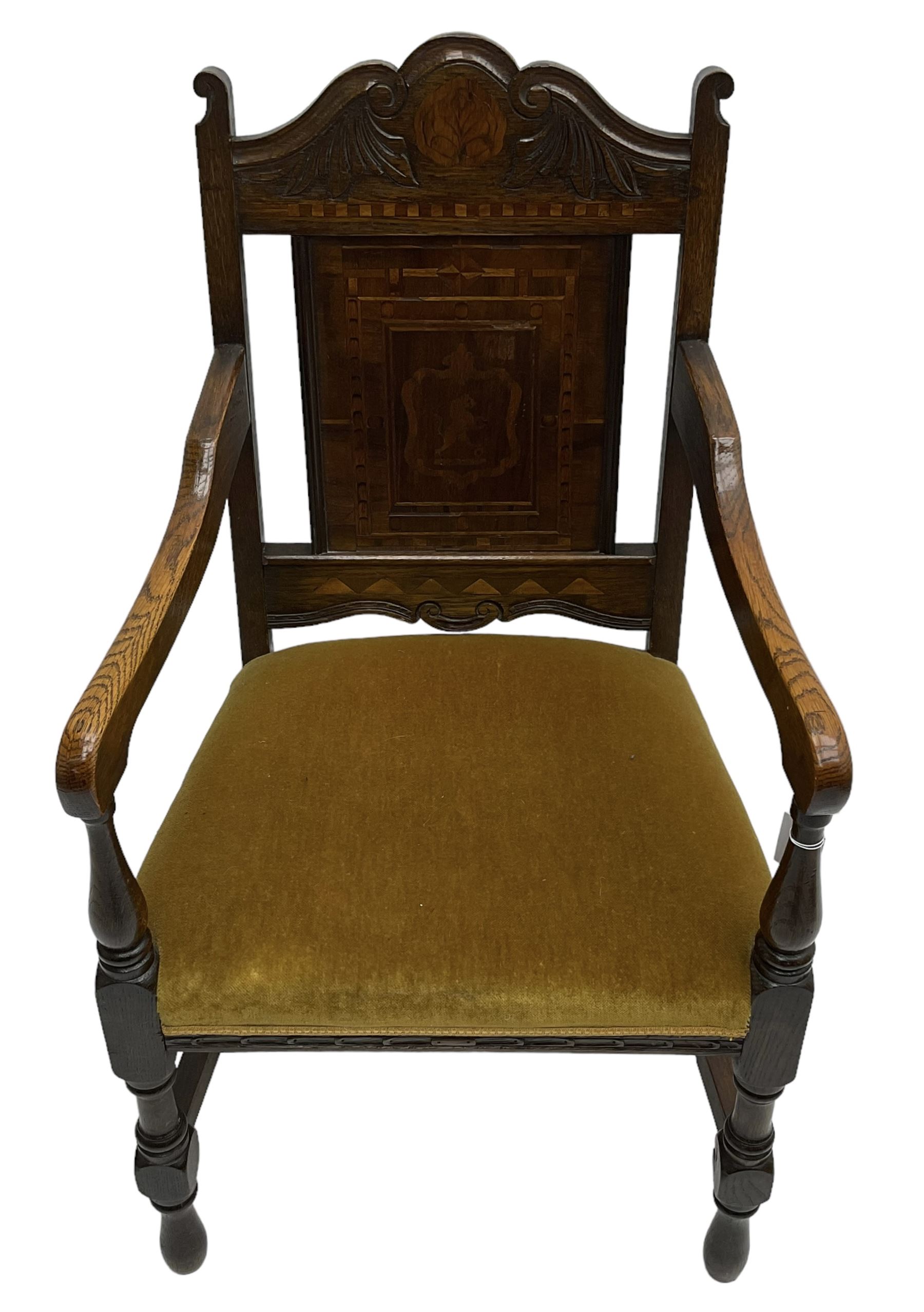 Late 19th to early 20th century oak elbow chair, the shaped cresting rail carved with scrolls and foliage, panelled back inlaid with parquetry work and central rampant lion within shield, upholstered seat, on turned supports joined by H stretchers