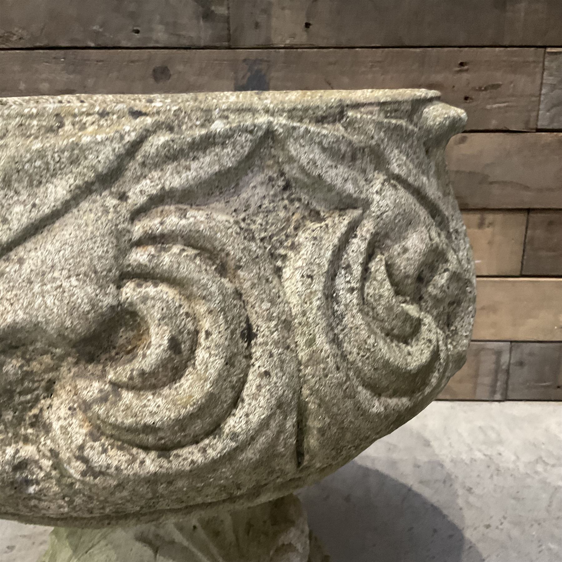 Cast stone circular garden urn decorated with scrolling foliate relief pattern