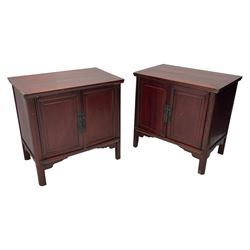 Pair of early 20th century Chinese red lacquered elm storage cupboards, rectangular top over two panelled doors, fitted with two internal drawers, on square supports with curved outer edge, panelled sides