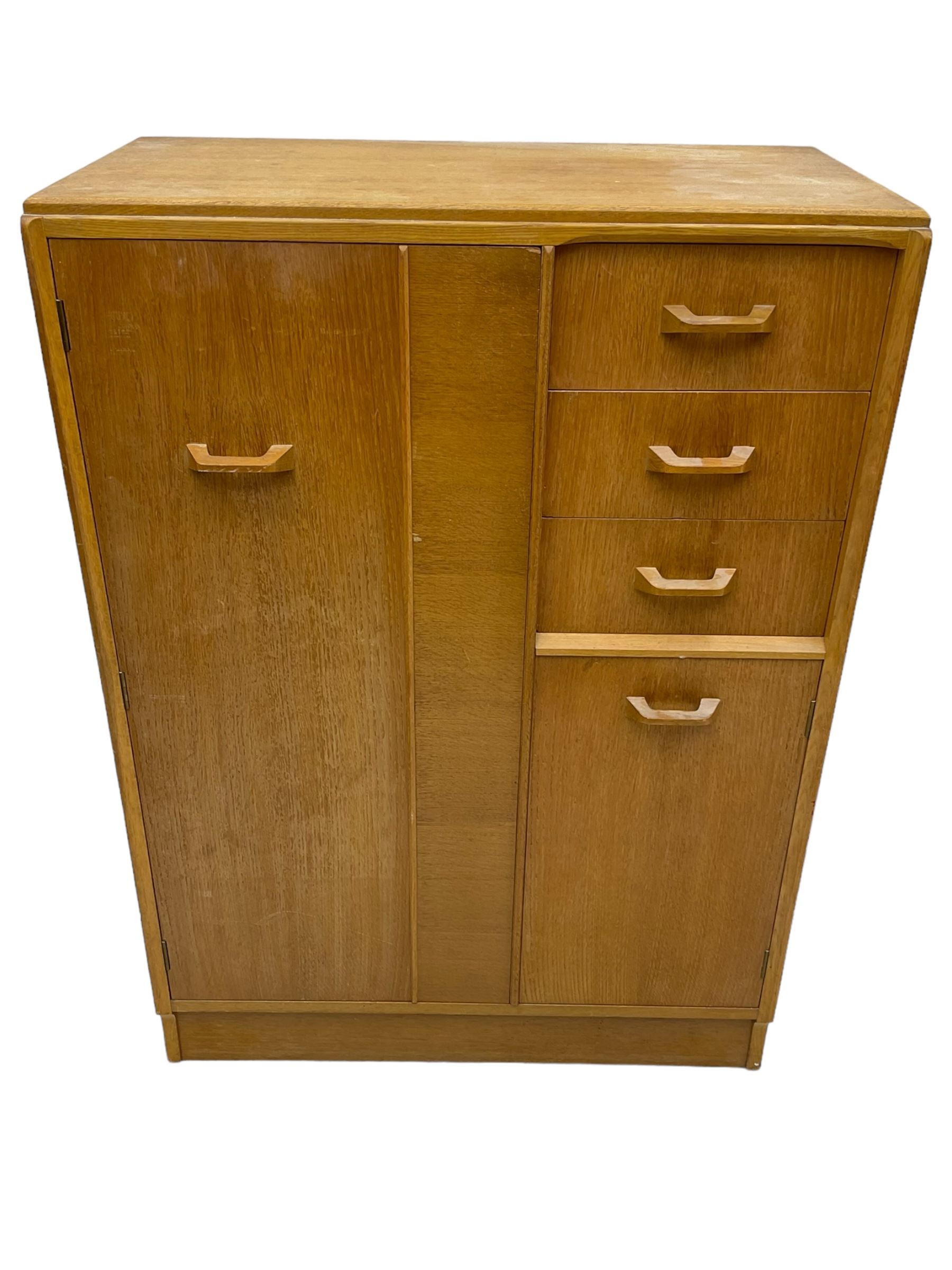 G-Plan - mid 20th century teak tallboy or combination wardrobe, left side with full-height hanging cupboard, right side with three drawers, the top fitted with vanity mirror, above cupboard with shelves, raised on a plinth base