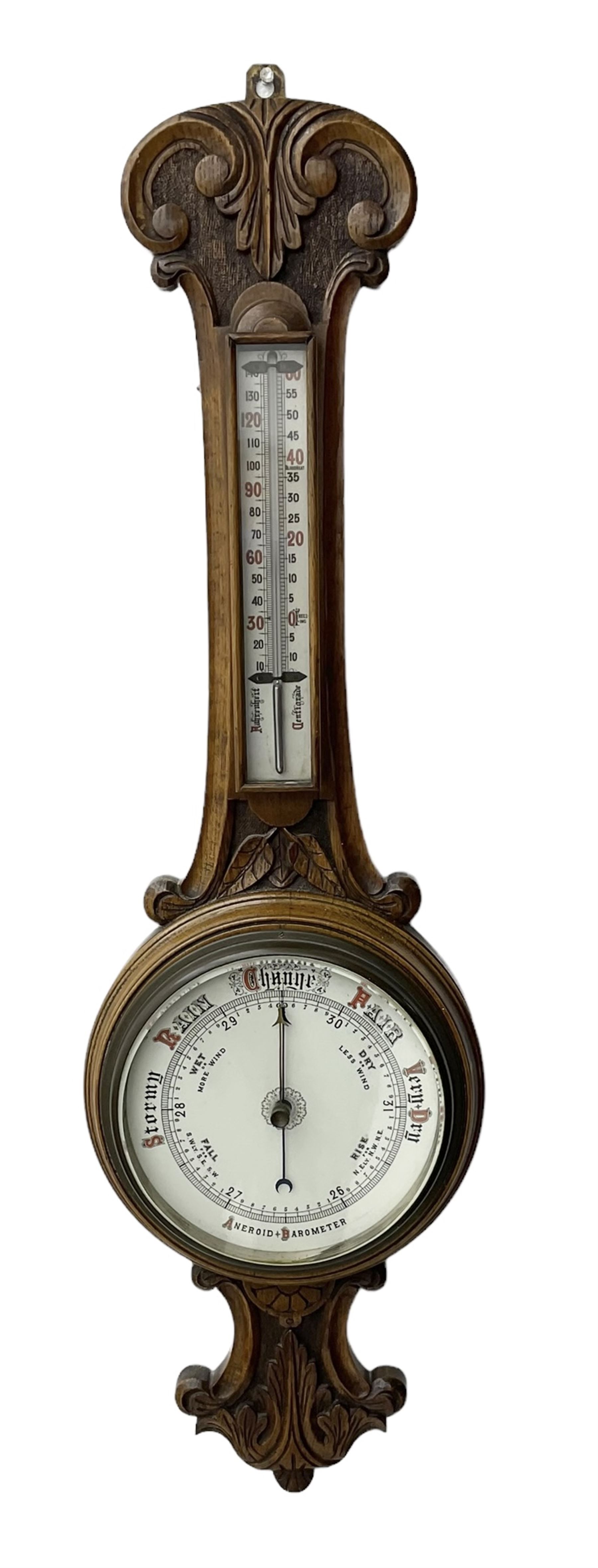 Edwardian - carved oak aneroid barometer, with a rounded top carved with scroll work, 8