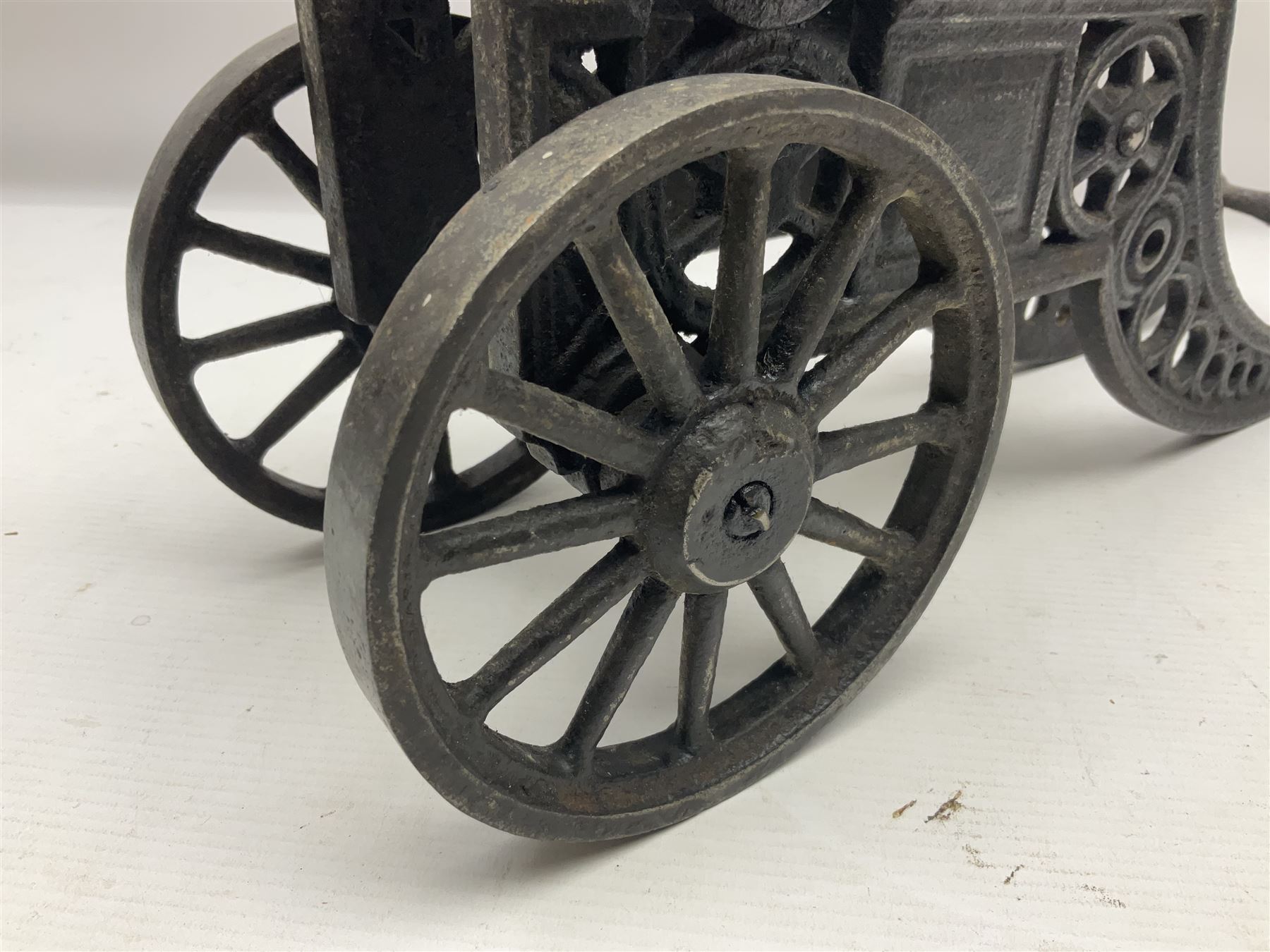 Victorian cast-iron and steel signal cannon, approximately half-inch bore, with 23cm ringed barrel and cylindrical trunnions, on a cast iron carriage with two twelve-spoked wheels and guilloche pierced swept back support, L43cm overall