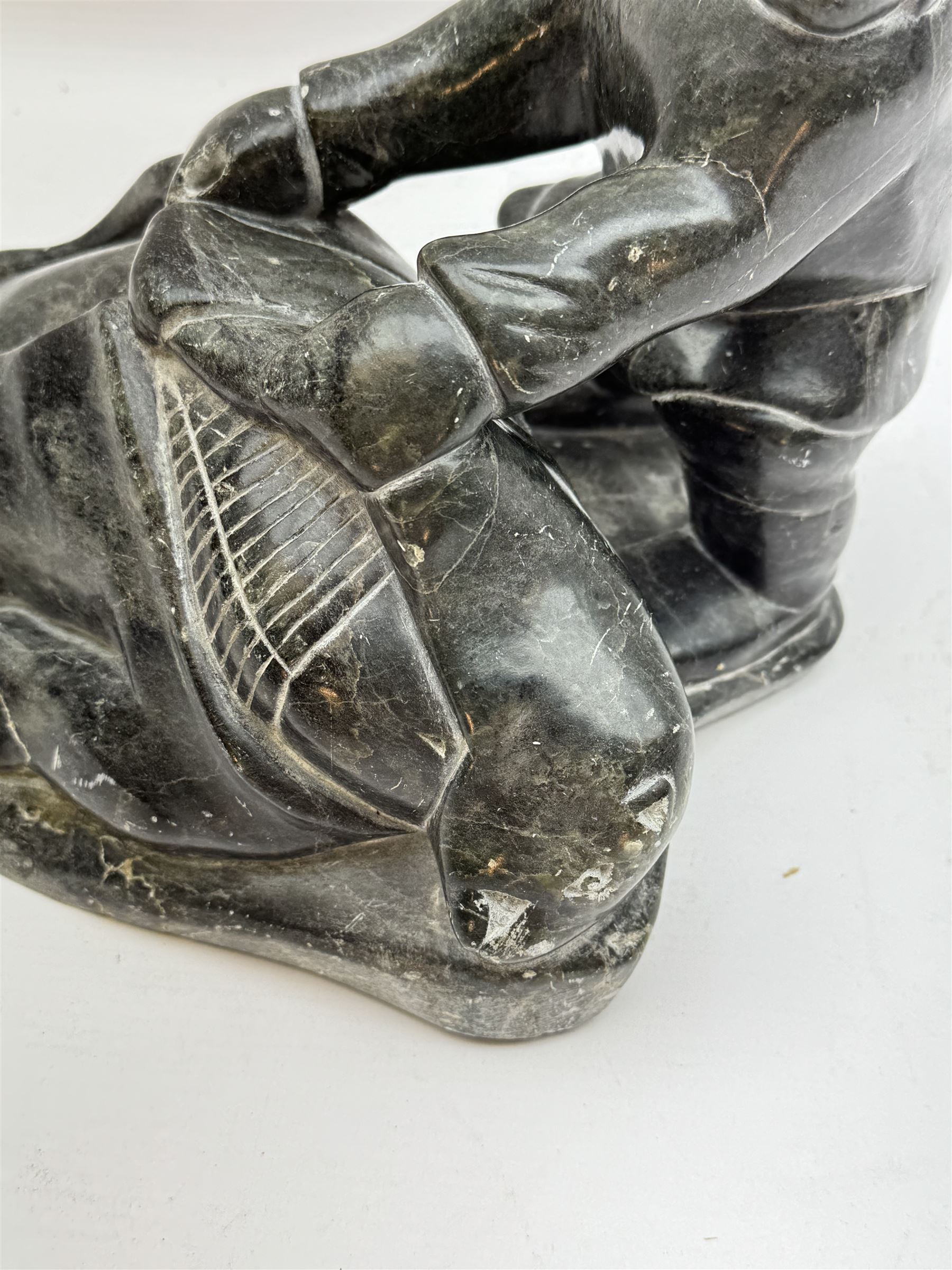 Inuit soapstone carving, of a hunter and a polar bear, circa 1960, H19cm 