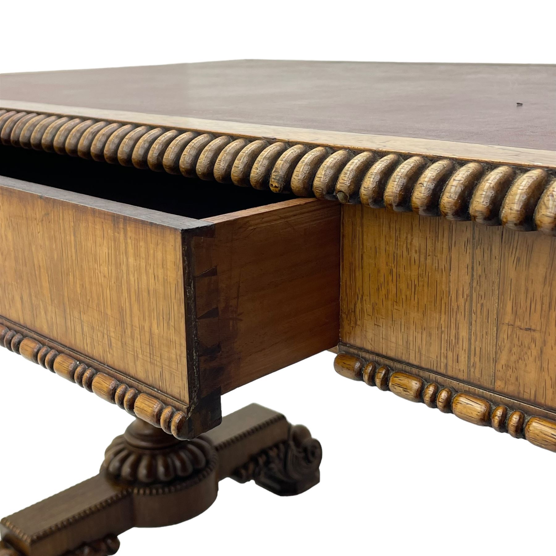 Early 19th century Regency rosewood writing table, rectangular top with inset leather writing surface and gadroon moulded edge, fitted with single frieze drawer, on twin turned pillar supports with lobe carved balusters, on platforms with beaded edge, acanthus scroll carved feet