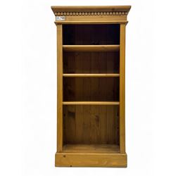 Contemporary pine bookcase, projecting moulded cornice with dentil frieze over three adjus...