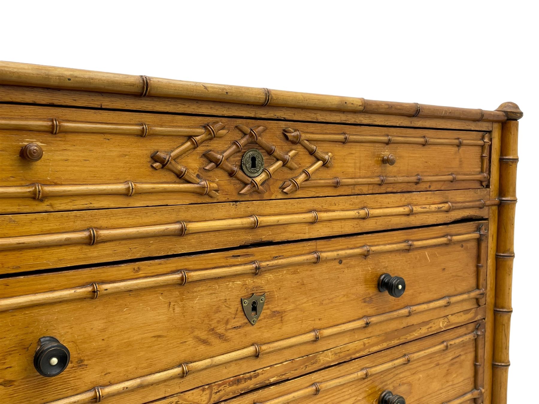 Victorian pine and simulated bamboo chest, fitted with five drawers, the drawer fronts decorated with applied simulated bamboo mounts and turned ebonised handles, on turned front feet