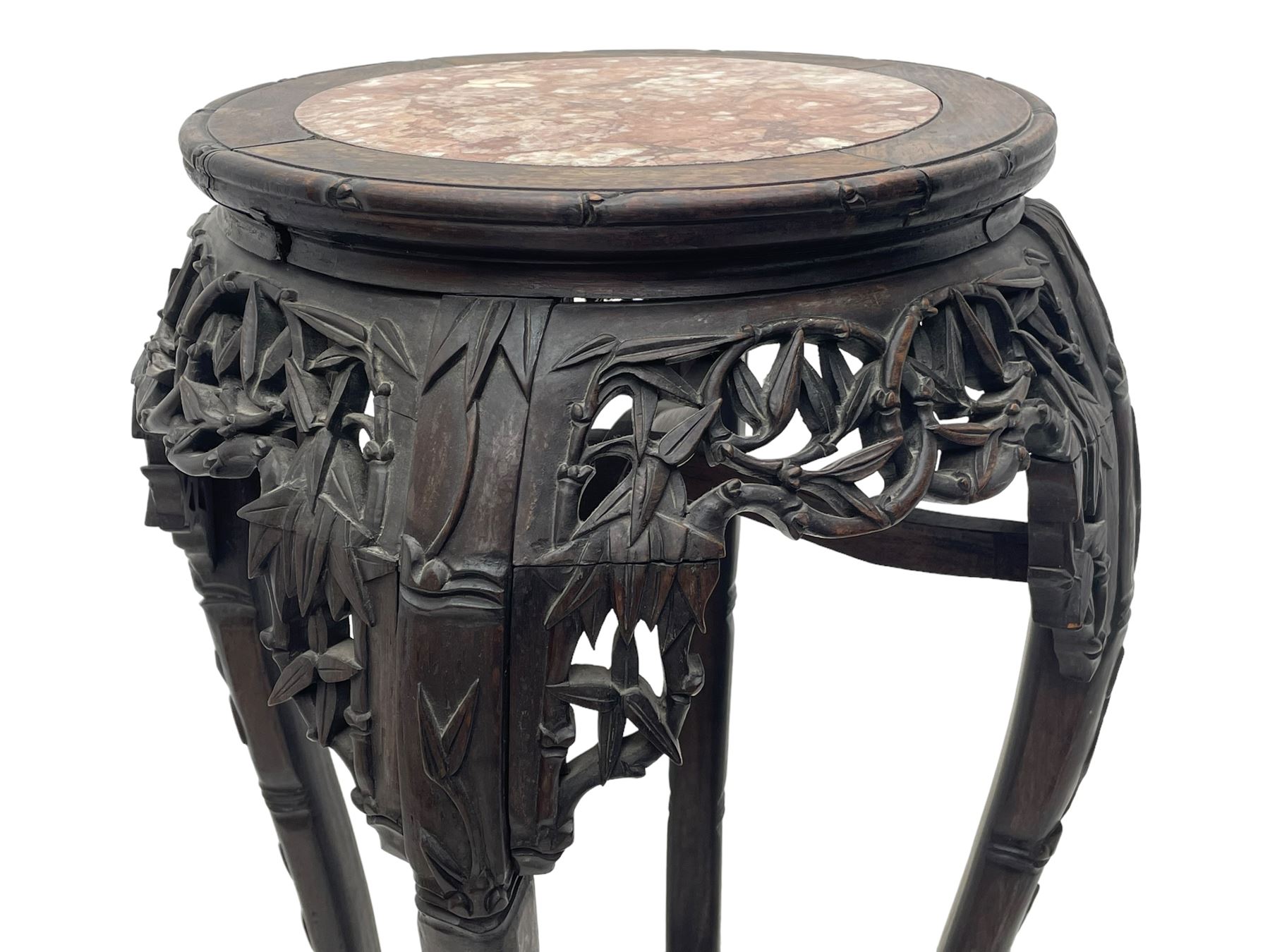 Early 20th century Chinese hardwood plant stand, circular top with marble inset, carved and pierced with interlacing foliage, on leaf carved supports united by x-framed stretchers