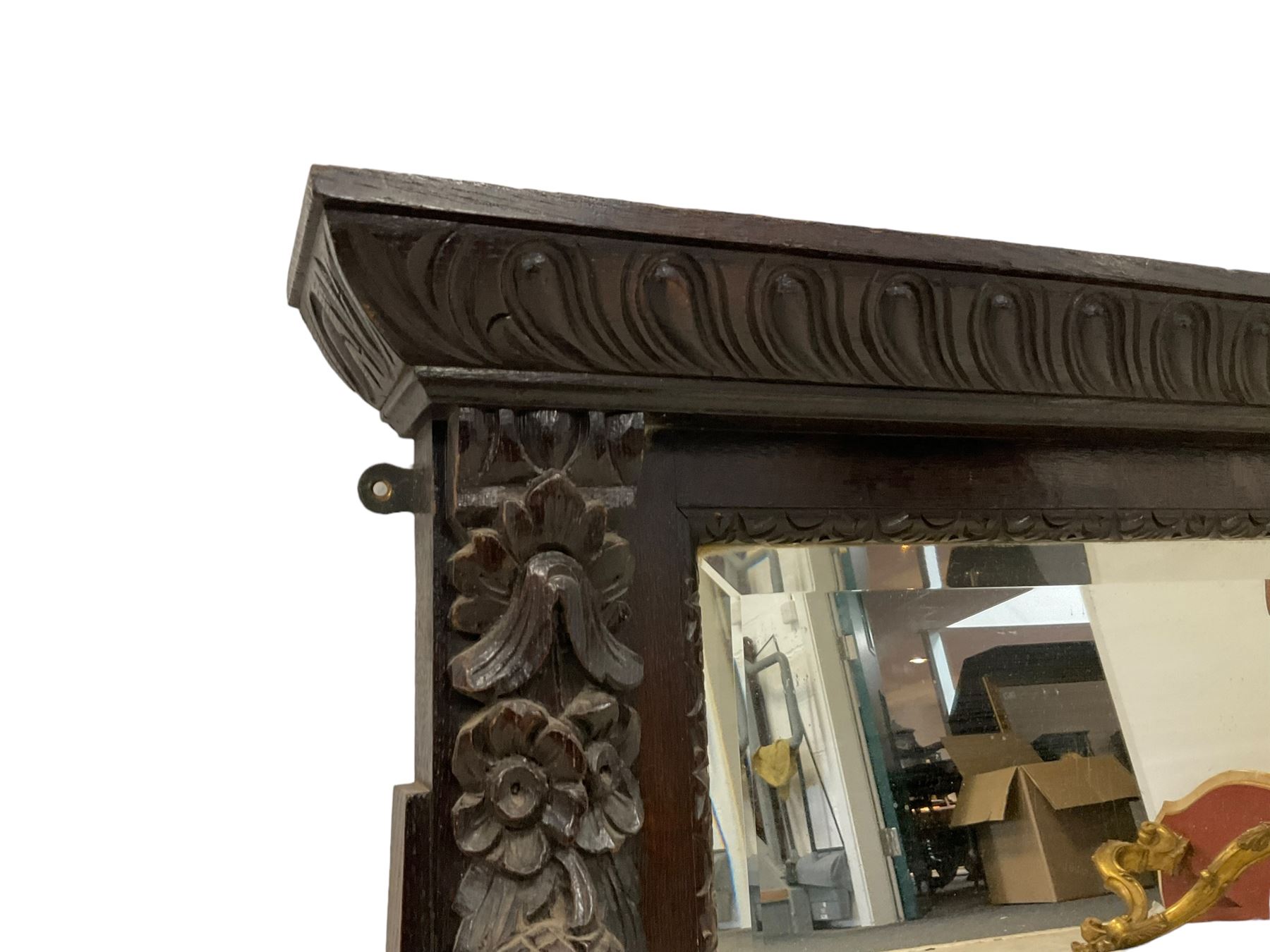 Victorian heavily carved oak wall mirror, projecting gadroon carved ovolo cornice, bevelled mirror plate within a lunette carved frame, decorated with applied fruit and foliage carved mounts, scroll carved brackets 