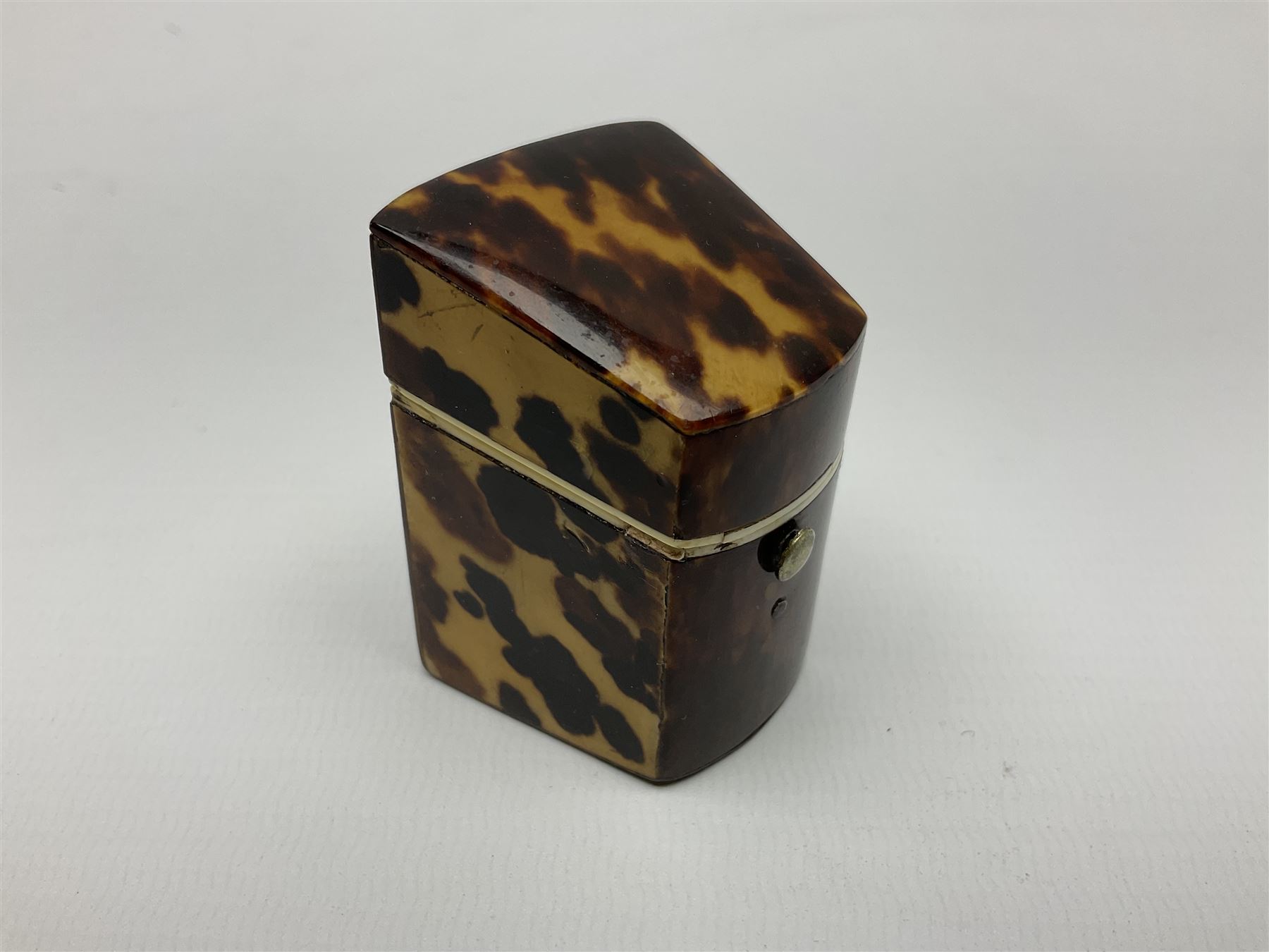 19th century tortoiseshell needle packet box of wedge form, with compartmented interior, H5.5cm, together with a 19th century tortoiseshell card or note case of book form, with inlaid silver motif to centre, the interior with card pocket, H7cm W7cm, (2)