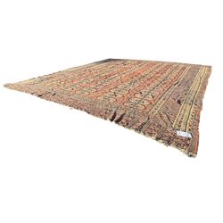 Bokhara red ground carpet, the central field featuring a repeating pattern of traditional octagonal guls arranged in vertical rows, bordered by multiple guard bands with geometric designs, finished with fringed ends