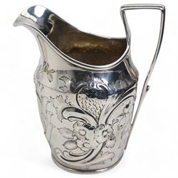 George III silver cream jug with later embossed decoration London 1797 Maker Thomas Meriton and a silver mustard pot with blue glass liner London 1931 Maker William Comyns & Sons Ltd (2)