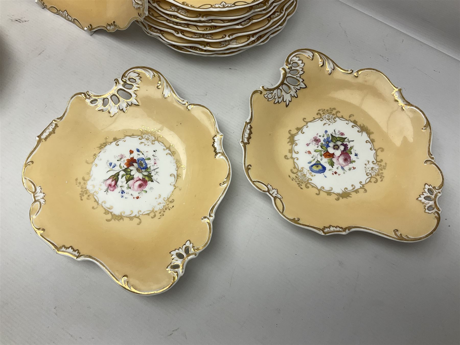 Victorian part dessert service, including eighteen plates, four small serving dishes, shallow dish, etc hand painted with floral sprigs within a cream border with floral panels, and heightened in gilt (26cm)