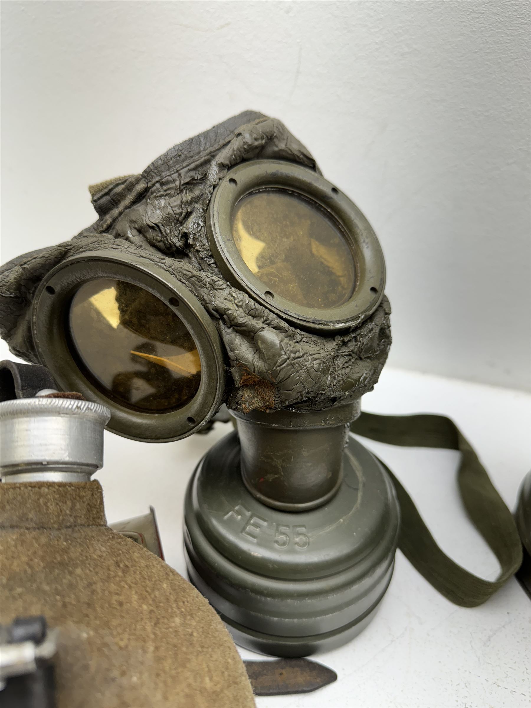 Two WWII German army canteen water bottles, together with German gas mask marked FE55 in a green fluted tin canister