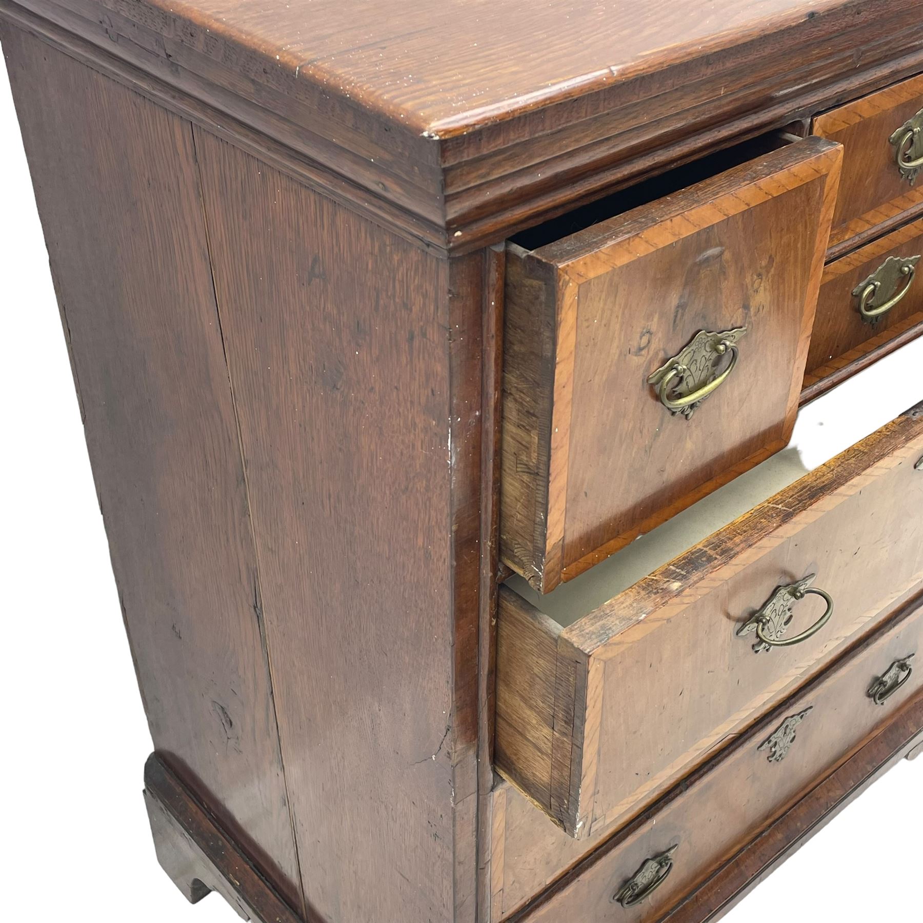 18th century oak and walnut chest, fitted with four small over three long drawers with figured walnut facias, brass handles and plates with engraved decoration, on bracket feet