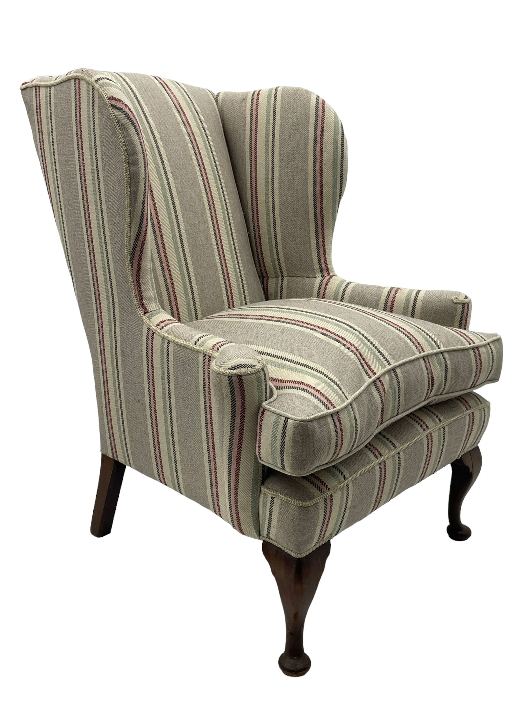 Georgian design hardwood-framed wingback armchair, curved wingback terminating to curved and rolled arms, upholstered in striped fabric with loose seat cushion, on cabriole front feet 