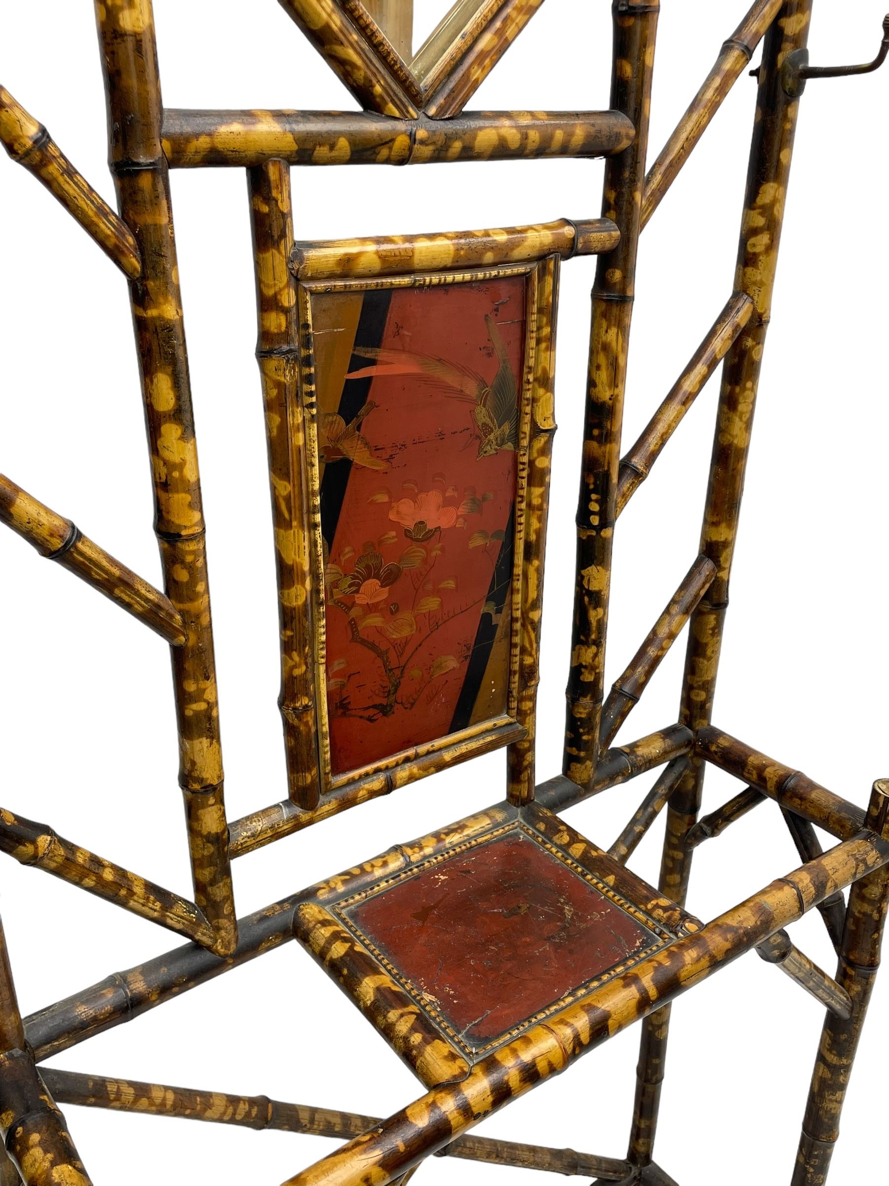 Victorian bamboo hallstand, bevelled mirror over red lacquered and chinoiserie decorated panels, fitted with six brass hooks 