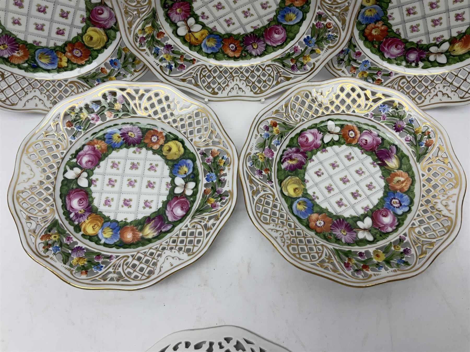 Six Dresden plates, with a pierced and fret border, with gilt rim and painted flower, with printed mark beneath, D18cm