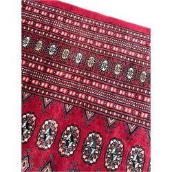 Persian Bokhara red ground carpet, decorated with six rows of traditional Gul motifs, multiple band border decorated with geometric patterns and motifs 