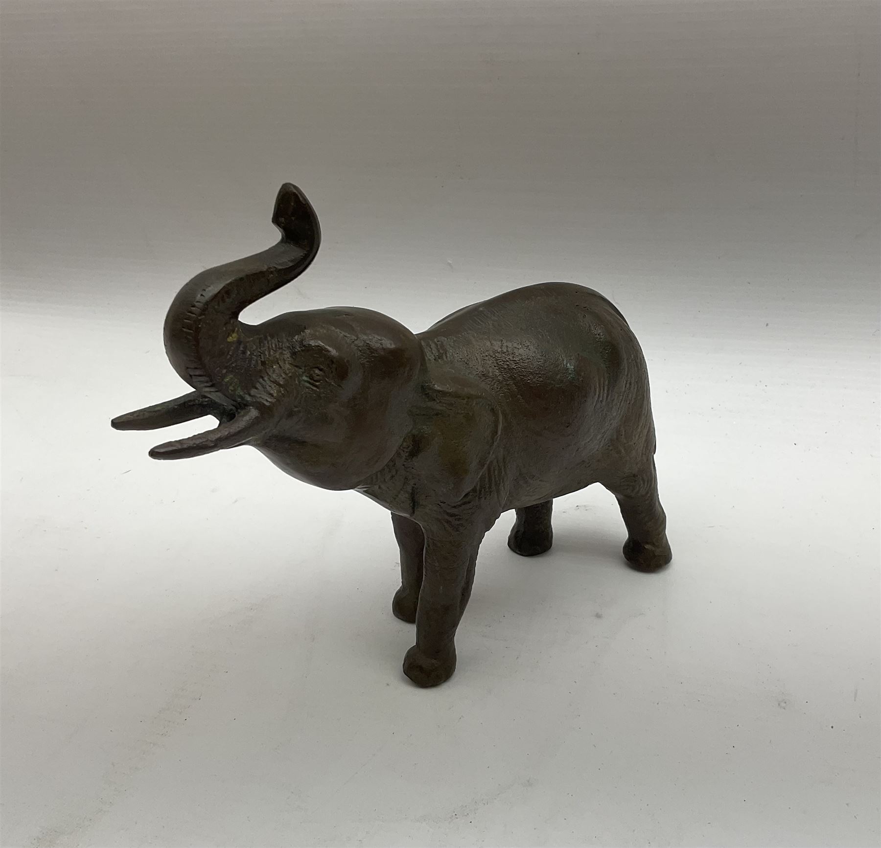 Two bronzed animal figures, the first modelled as an Indian elephant, H16cm, the second as a stag, H11cm