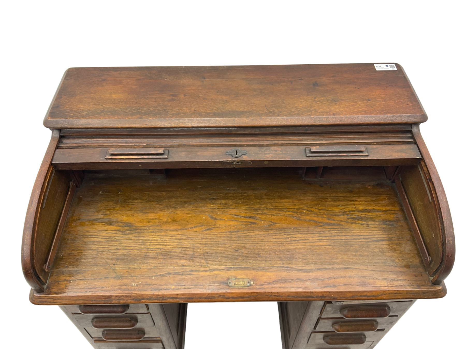 Early 20th century oak twin pedestal roll top desk, tambour roll enclosing fitted interior, each pedestal fitted with four drawers and slide, on plinth base 