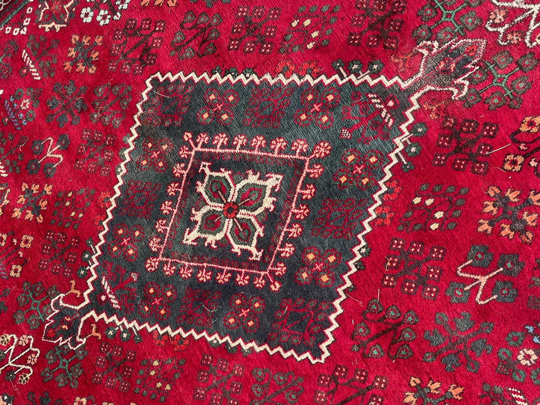 Persian Meymeh red ground rug, stepped lozenge medallion and spandrels, decorated all over with tree of life motifs, the main border decorated with repeating stylised plant motifs within geometric guard stripes 