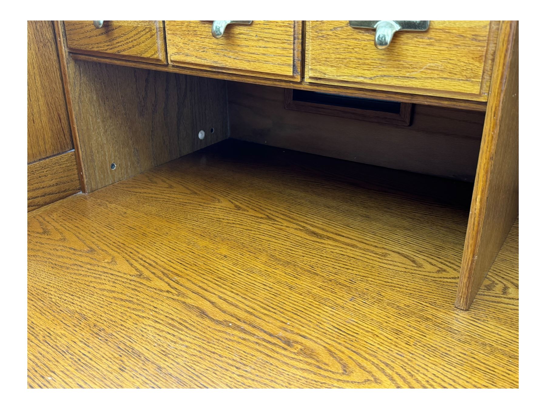 Early 20th century oak tambour roll-top desk, the top with fitted interior including drawers, pigeonholes and compartments, the twin pedestals fitted with four drawers with carved handles, supported by plinth base 