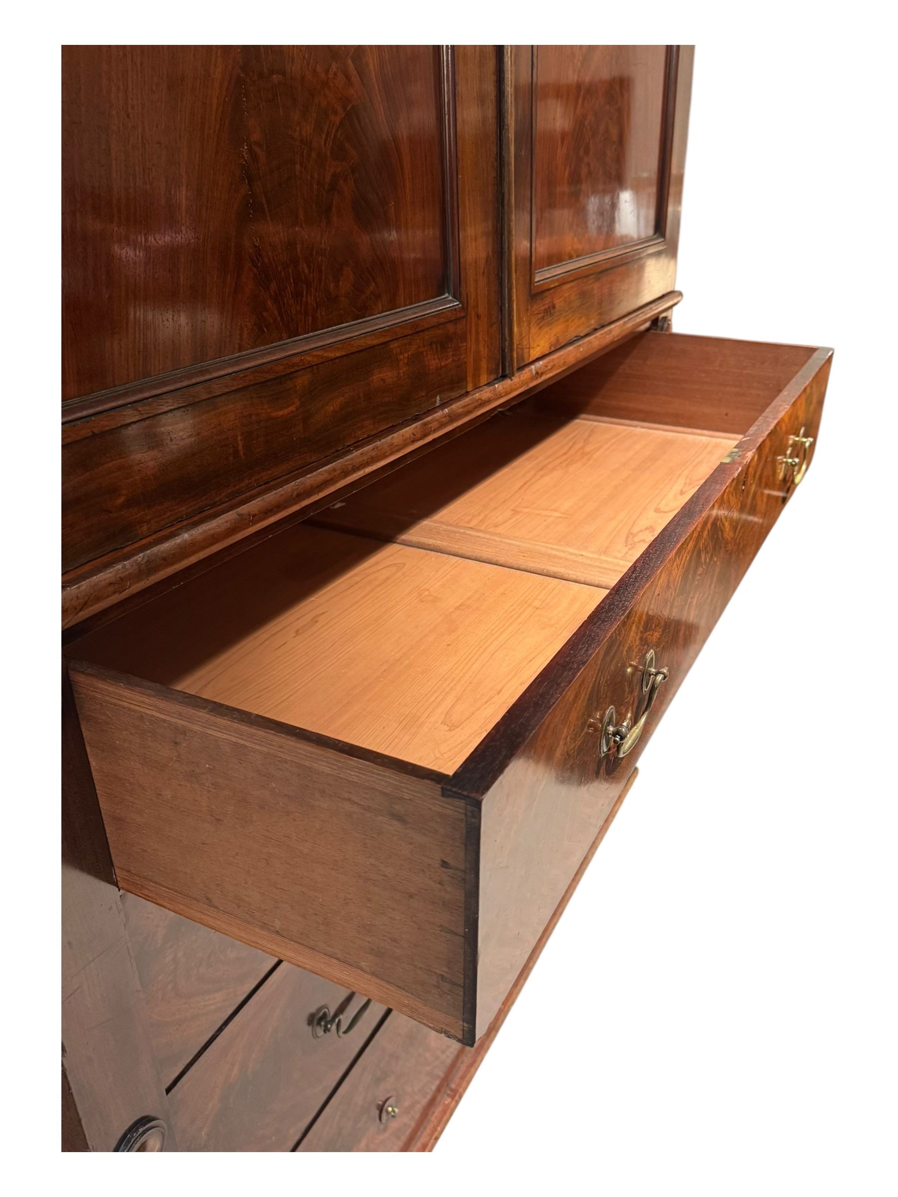 Victorian mahogany linen-press, moulded cornice over two figured panelled doors, the interior fitted with five slides and hanging rail, four long drawers below 