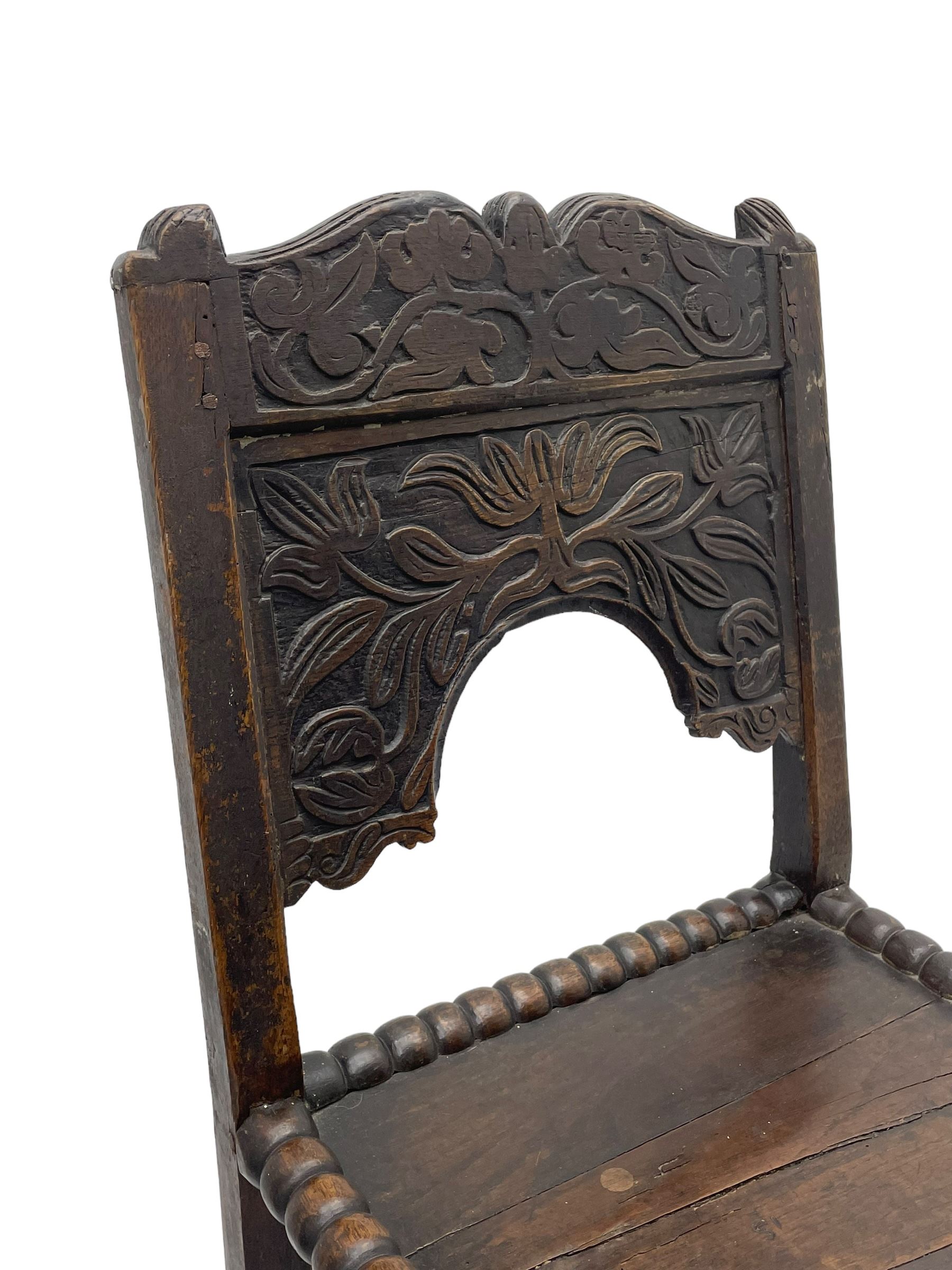 Set of three 18th century carved oak back stools, the cresting rail carved with scrolling foliate motifs over an arched panel with a stylised tree carving with extending leafage, the panelled seat held within a bobbin-turned frame, raised on turned supports united by a ring-turned front stretcher