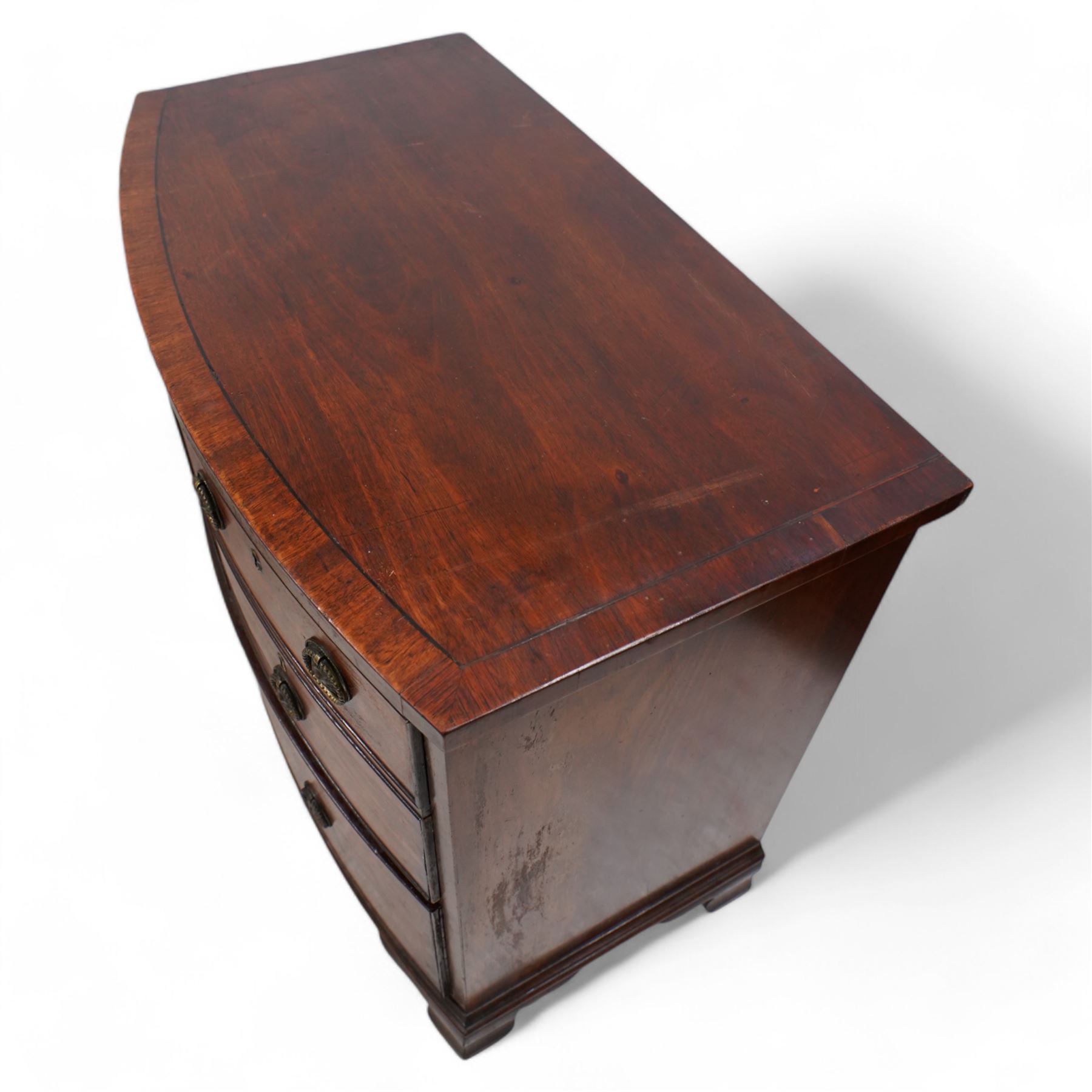 George III mahogany bow-fronted wine chest, banded top over two short and single long drawer, the two short drawers with baize lining and divisions, on ogee bracket feet 