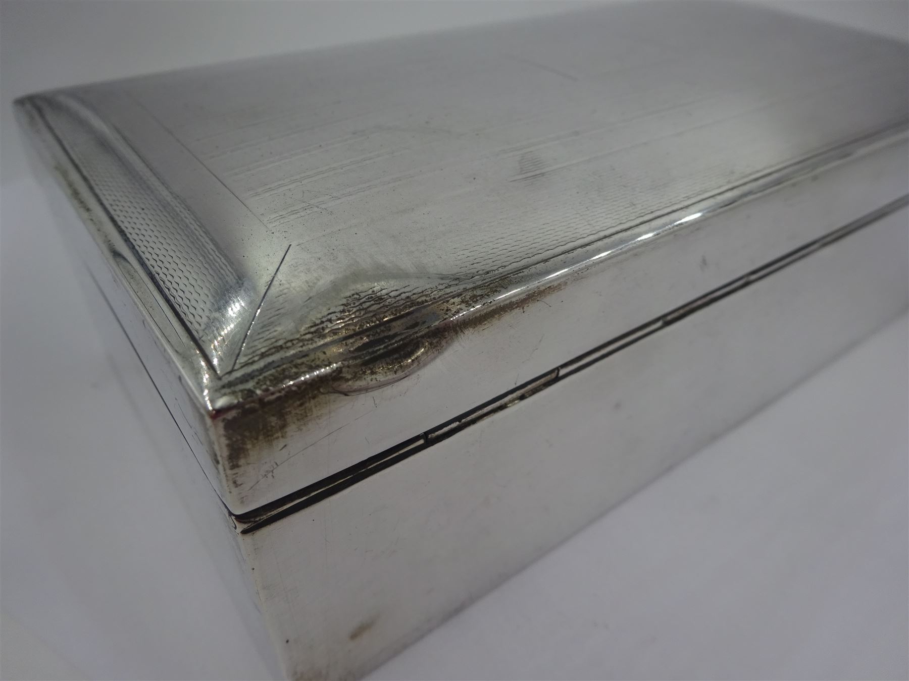 Mid 20th century silver mounted cigarette box, of rectangular form with engine turned decoration and blank cartouche to hinged cover, opening to reveal a softwood lined compartmentalised interior, hallmarked John Rose, Birmingham 1945, H5cm, W16.5cm