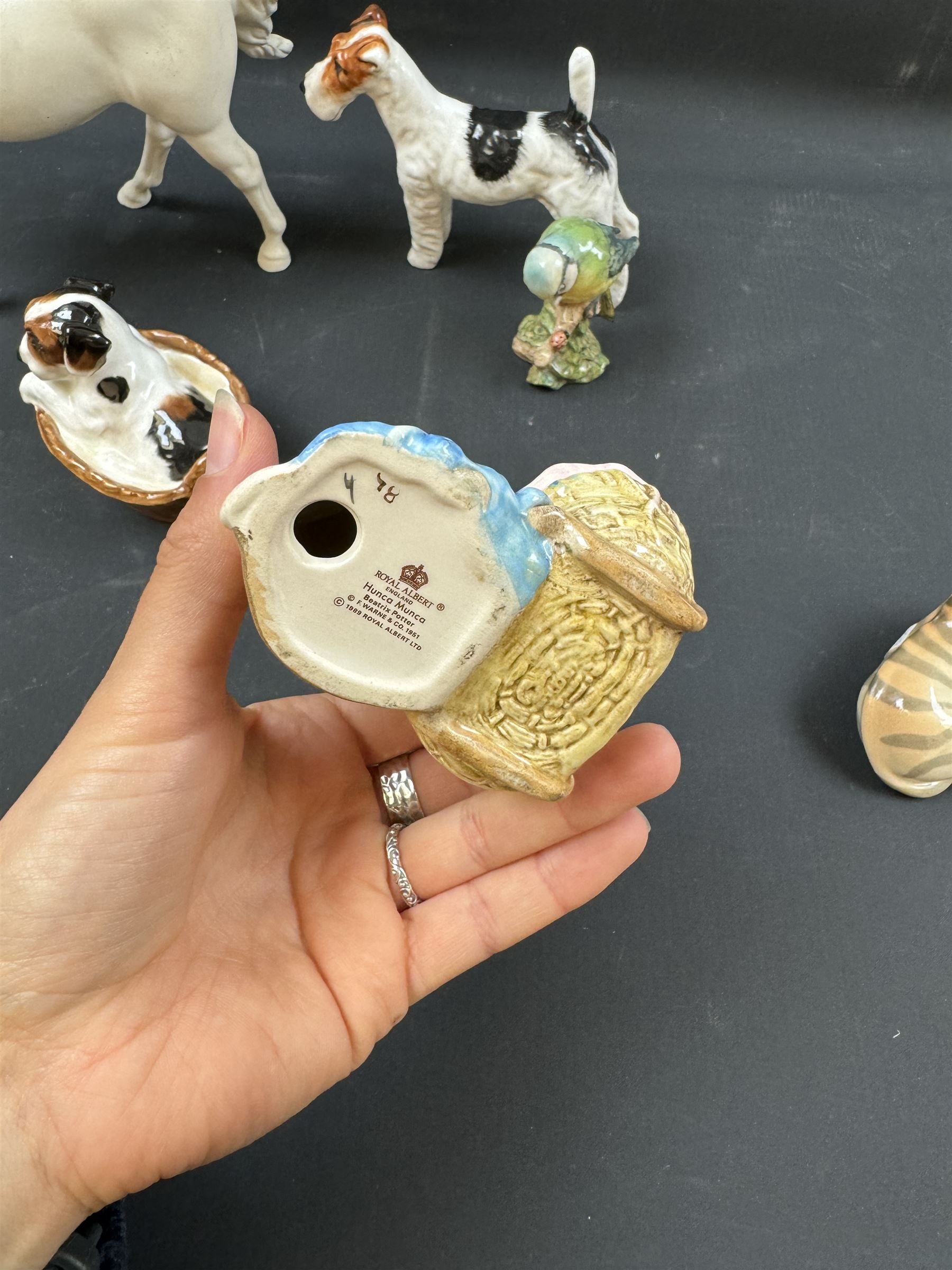 Two Royal Doulton figures of puppies in baskets, together with Beswick horse and other animal figures