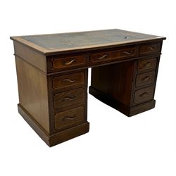 20th century oak twin pedestal desk, rectangular top with inset leather writing surface, fitted with nine drawers with chamfered edges to the raised panels, each with curved brass handles with scroll ends and keyholes, fluted detailing to the top and between the drawers, on moulded plinth base with castors