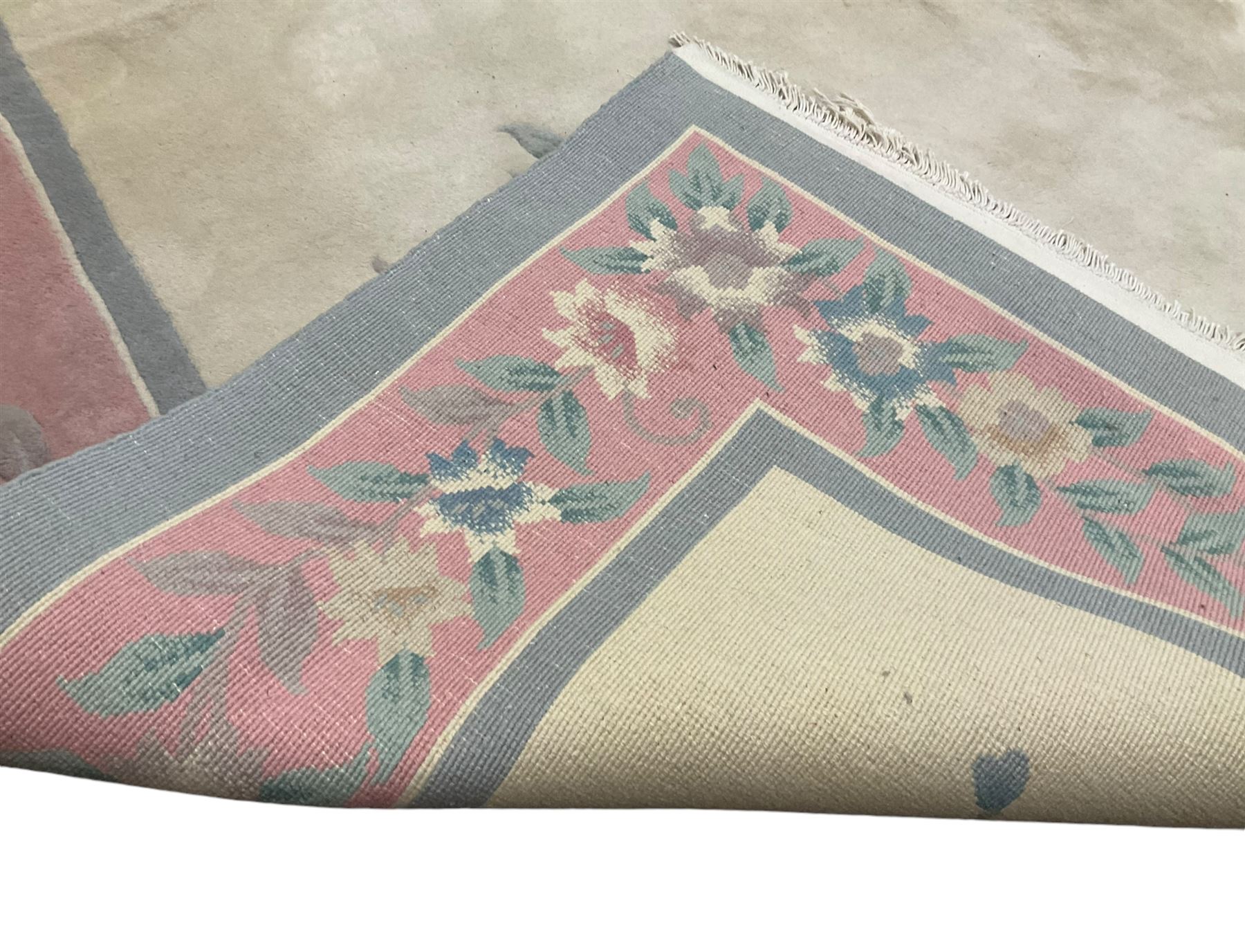 Chinese ivory ground washed woollen carpet, the field decorated with five large floral motifs with extending leafage, the wide rose guard band decorated with further floral patterns