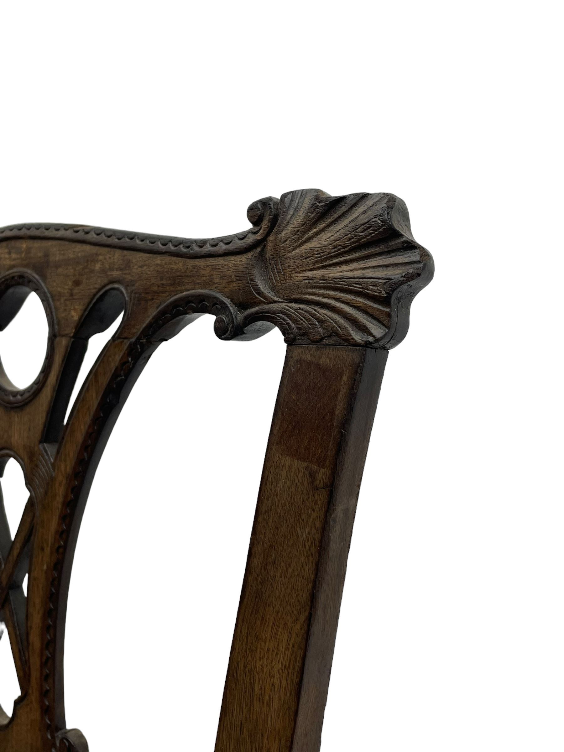 Unusual 18th century mahogany elbow chair, the shaped cresting rail with projecting shell carved ears, pierced and scroll carved splat over drop-in upholstered seat, shaped arms with ball and claw carved terminals, the seat rails carved with shell cartouches, on foliate carved cabriole supports with ball and claw feet 