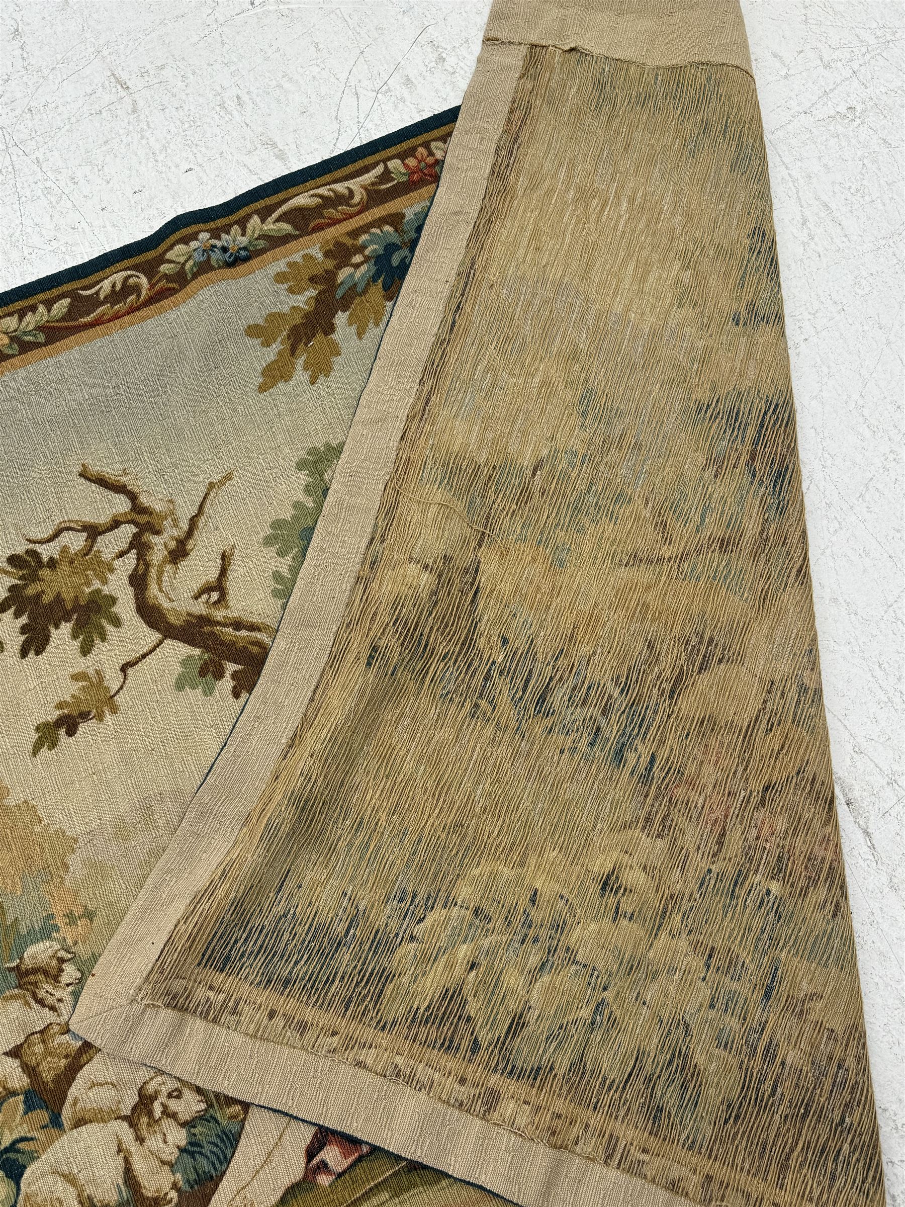 Large French machine woven tapestry, depicting figures in a landscape with a floral boarder 