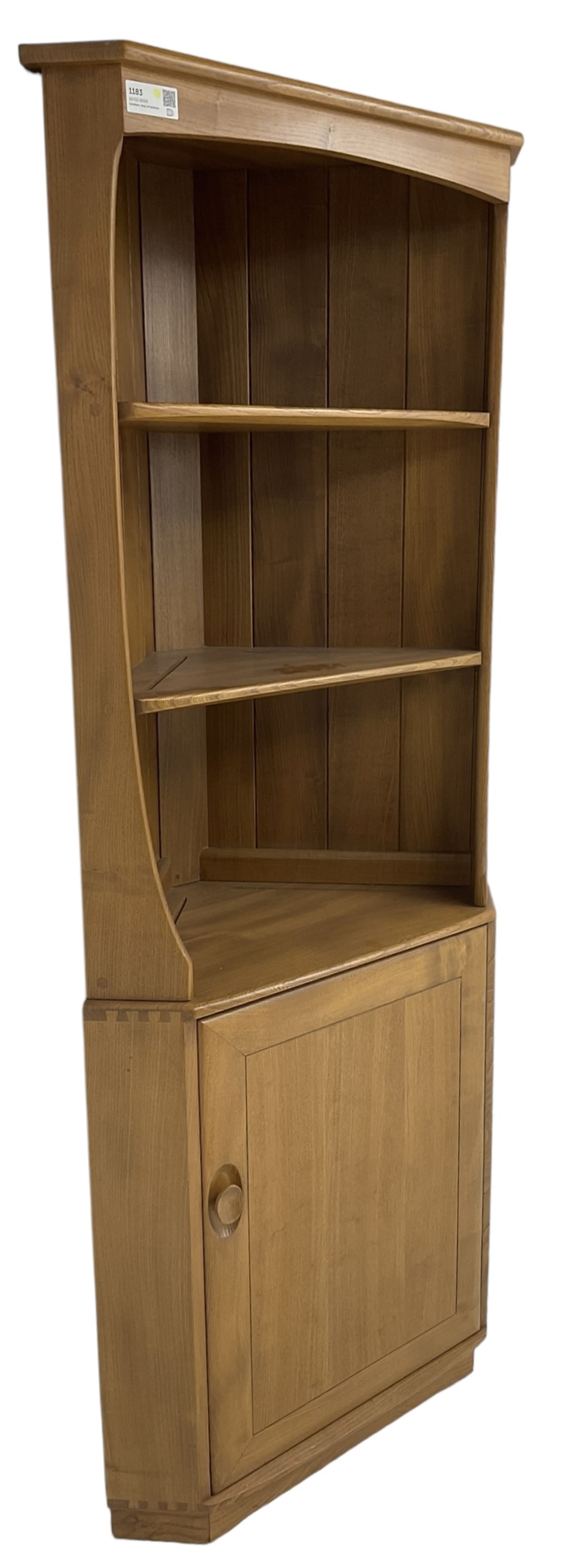 Ercol - mid-20th century '743C'  light elm corner cabinet, fitted with two open shelves over a single cupboard