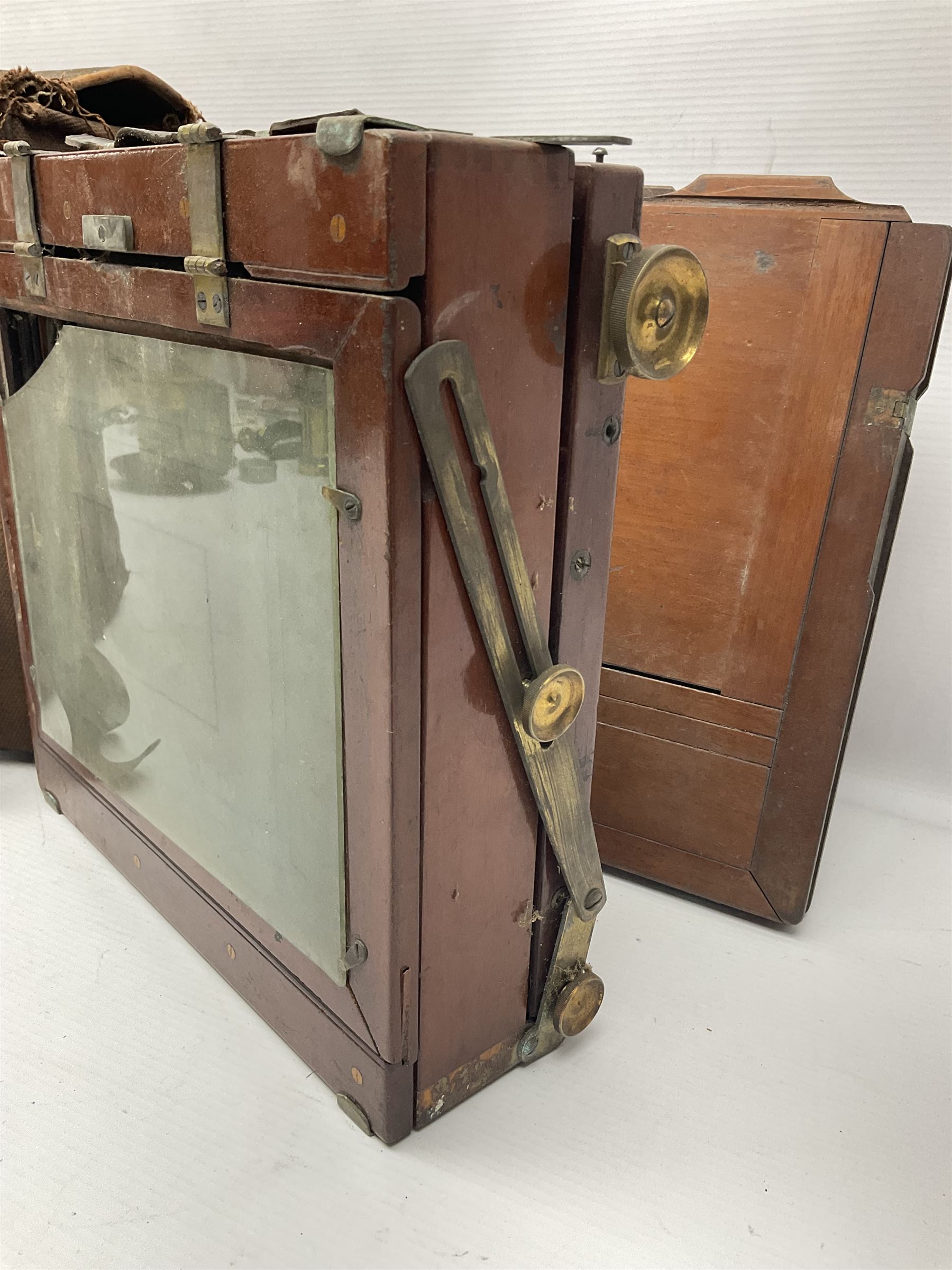 Folding plate camera in mahogany and lacquered brass, with additional plates and case