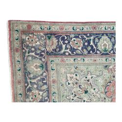 Persian rose ground rug, large central floral medallion surrounded by scrolling foliate and floral motifs, pale green spandrels, wide border in pale green and navy with intricate floral designs, framed by multiple guard stripes with repeating floral and geometric patterns