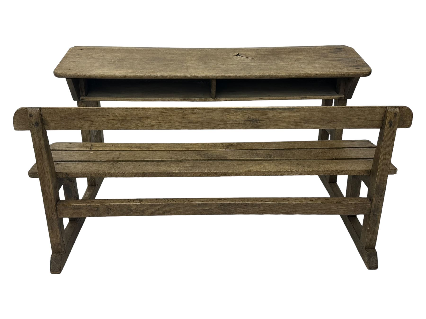 Victorian child's pine double school desk, the writing surface with two inkwells and two shelves underneath, integrated slatted bench seat raised on supports united by stretcher 