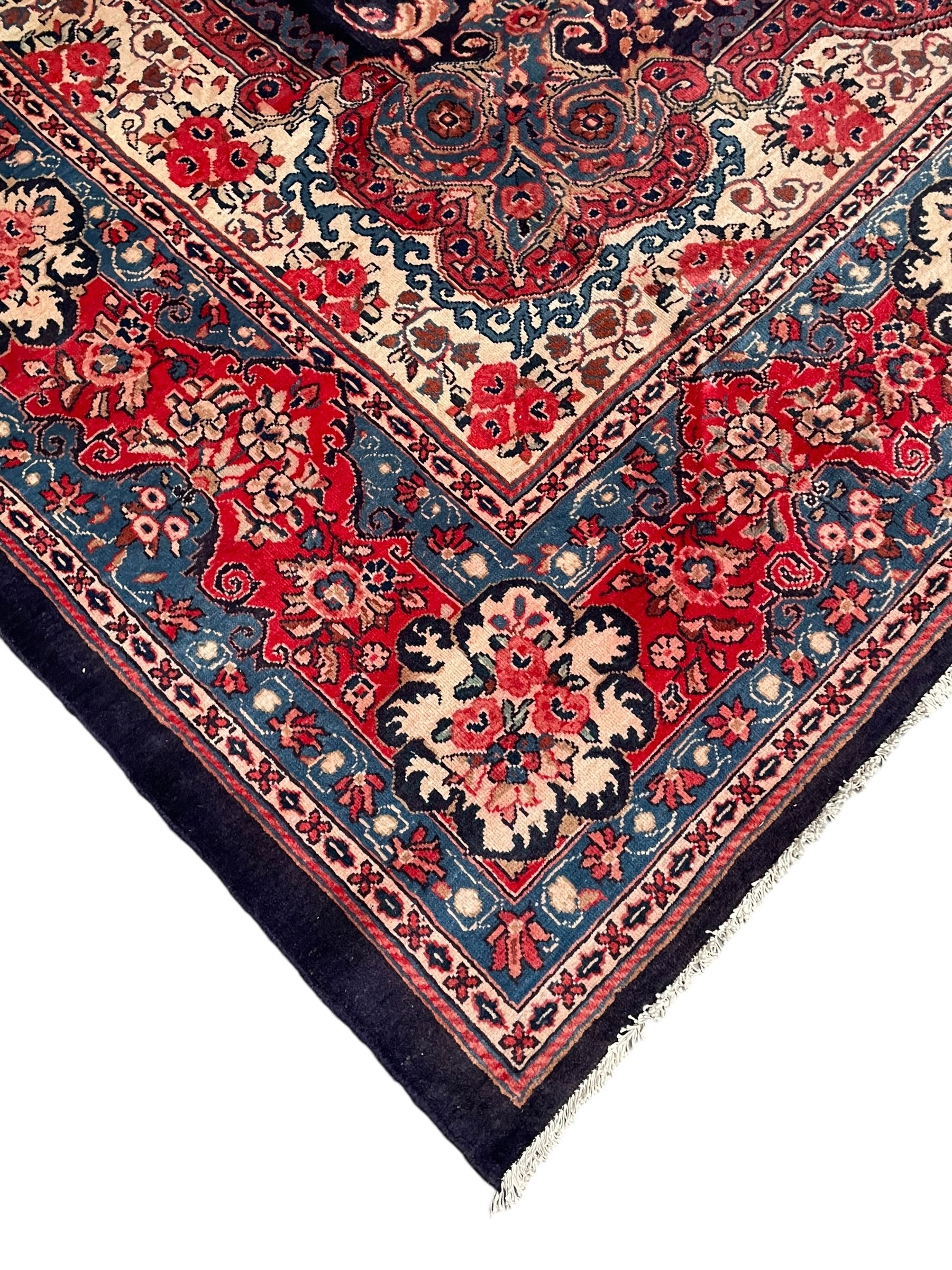 Persian Mahal indigo ground carpet, floral medallion on a field of swirling leafy branches and flower heads, shaped ivory field band decorated with flower head bouquets and trailing branches, the border decorated with floral motifs, within guard stripes