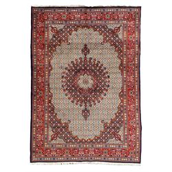 Persian Bidjar ivory and indigo ground rug, large central rosette medallion surrounded by floral herati motifs, crimson ground border decorated with repeating palmettes, within guard stripes decorated with small flower head motifs 