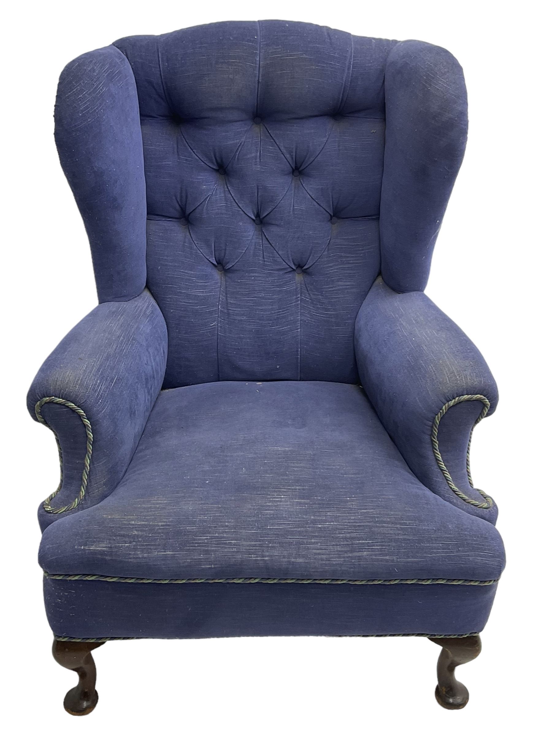 Early 20th century wingback armchair, upholstered in buttoned blue fabric, rolled and scrolled arms, on cabriole feet