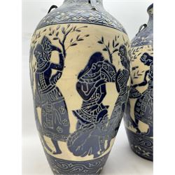 Pair of blue and white Cretan style vases, decorated with figures among trees with blue boarders on a white ground, H55cm