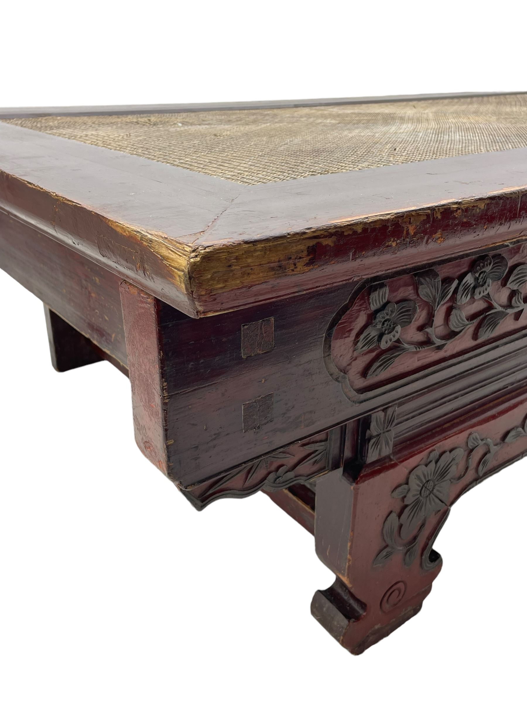 Mid-19th century Qing dynasty opium or wedding bed, Zhejiang province, rectangular top with weave cane work, the frieze rail carved with trailing leafy branches and flower heads, over moulded rail with small drawer, shaped base carved with further tailing foliate decoration terminating to shaped feet, united by stretchers 