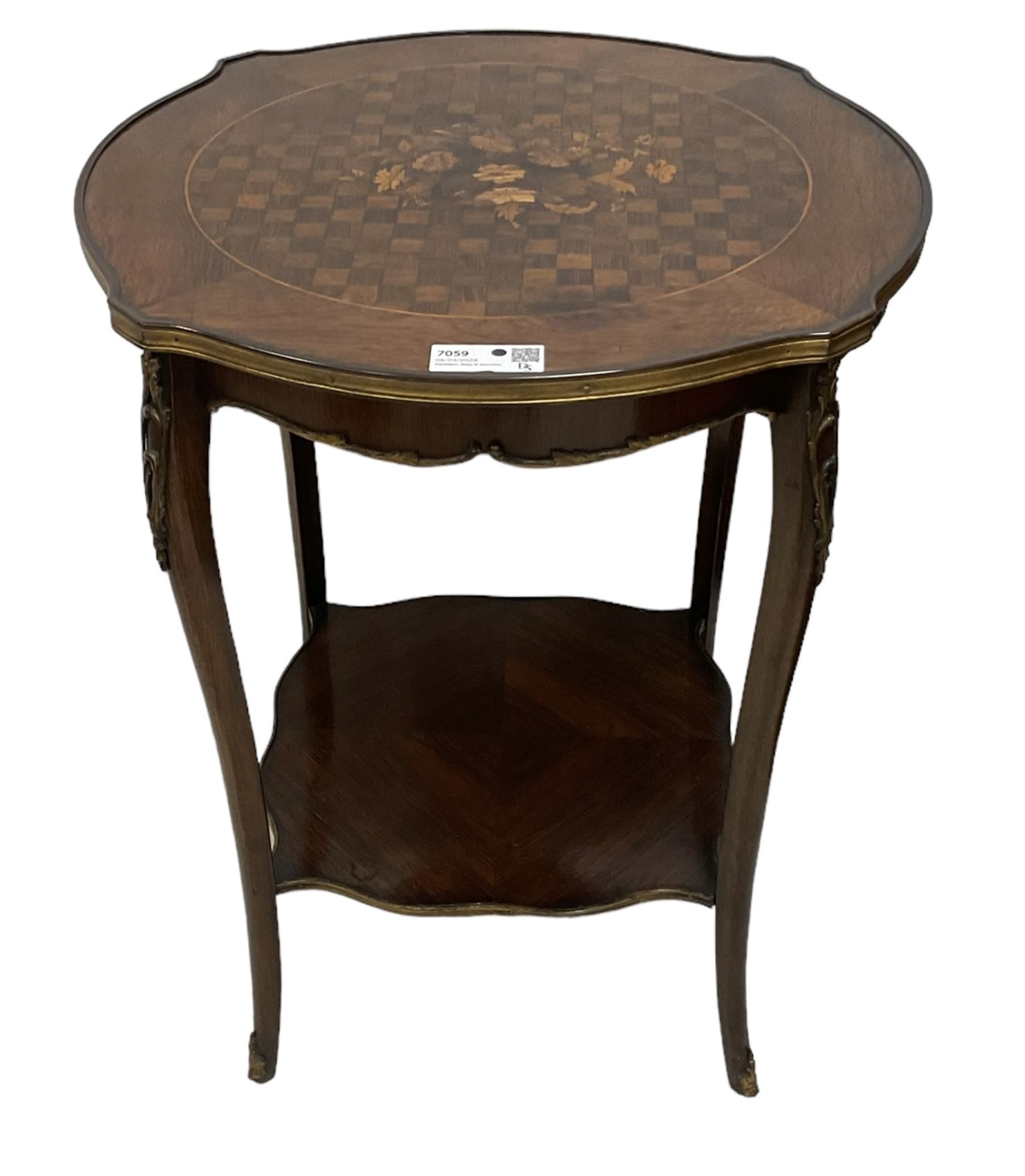 Early 20th century French two-tier marquetry inlaid walnut side table, shaped circular top with gilt metal edge, central chequered inlaid circular panel with floral motif, raised on cabriole supports with gilt metal mounts, united  by undertier