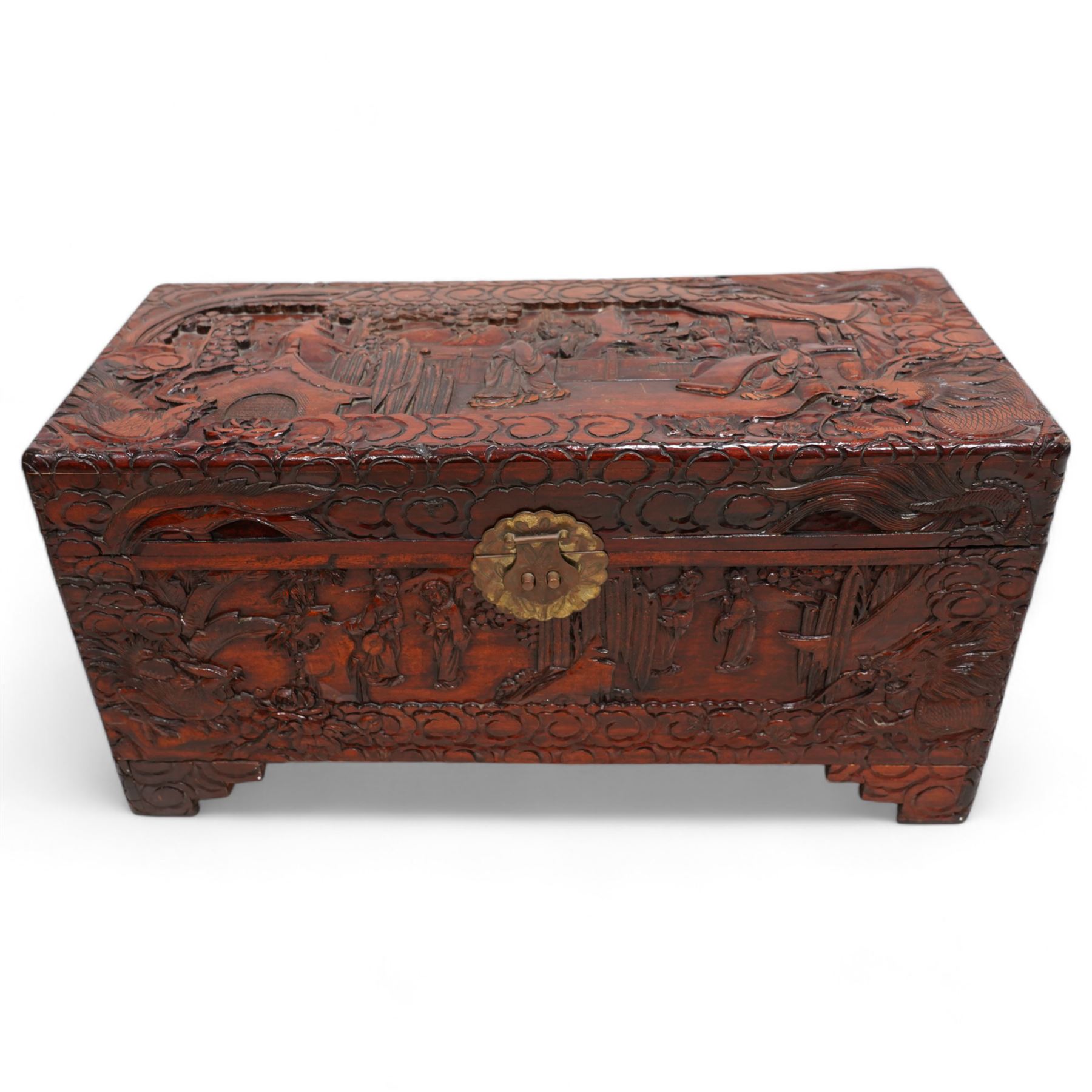 Chinese heavily carved and lacquered camphor wood blanket chest, rectangular hinged top, carved all-over with traditional figural and pagoda scenes with exotic birds, enclosed by a border of stylised clouds