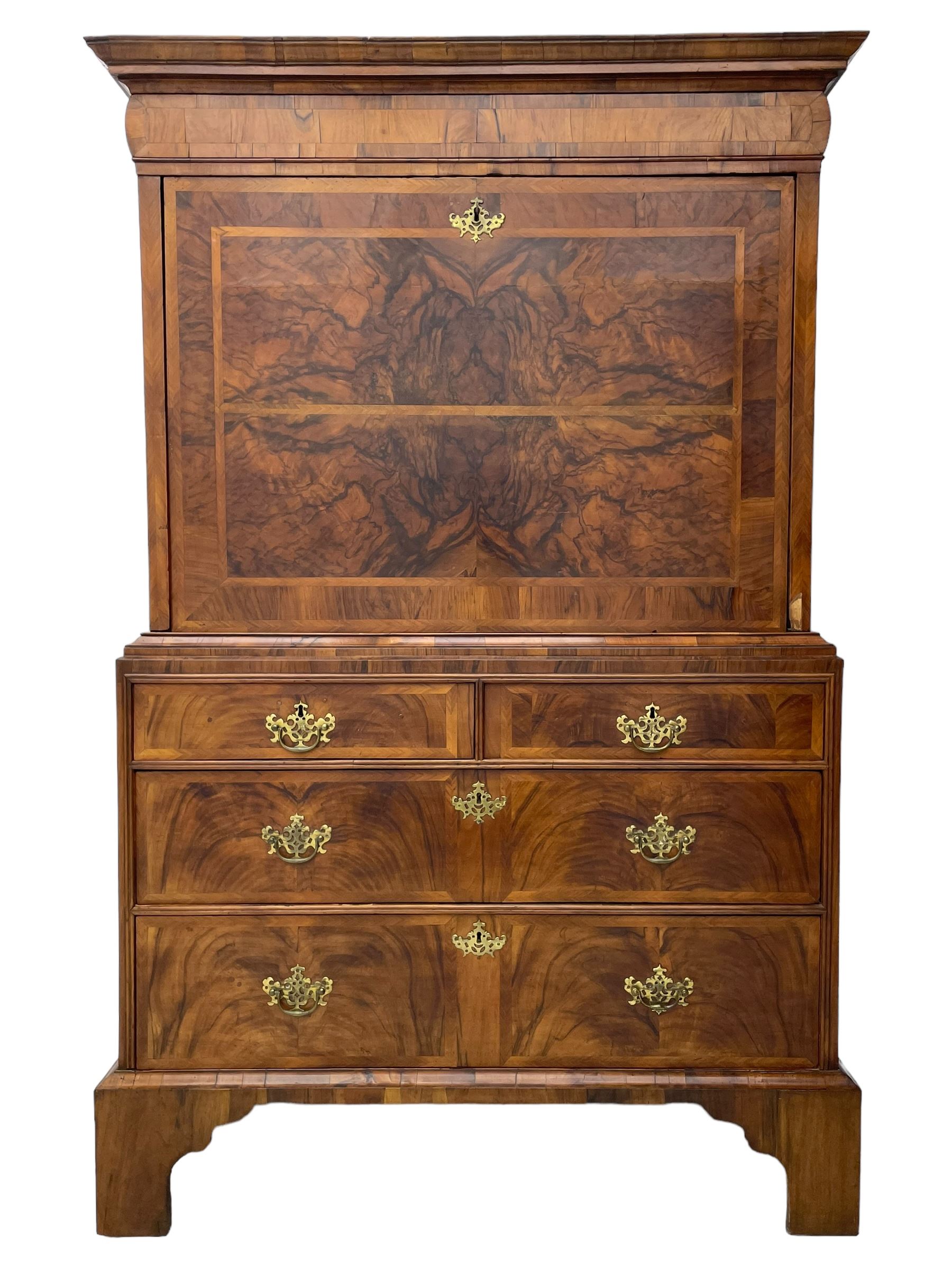 Early 18th century William & Mary figured walnut escritoire, projecting moulded cornice over shallow frieze drawer, the figured fall front enclosing interior fitted with small drawers, cupboards, pigeon holes and hidden drawers, the lower section fitted with two short and two long graduating drawers, on tall bracket feet 