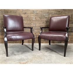 Two rosewood framed armchairs, upholstered in brown leather