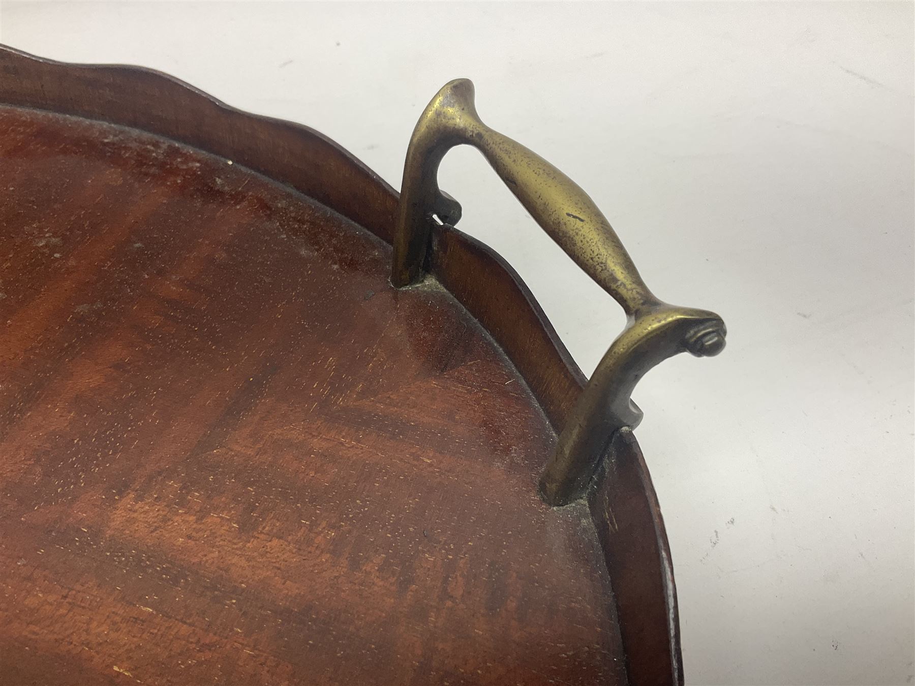 Early 20th century mahogany tray, of oval form with shaped rim and twin brass handles, with inlaid diamond decoration to centre, W67cm