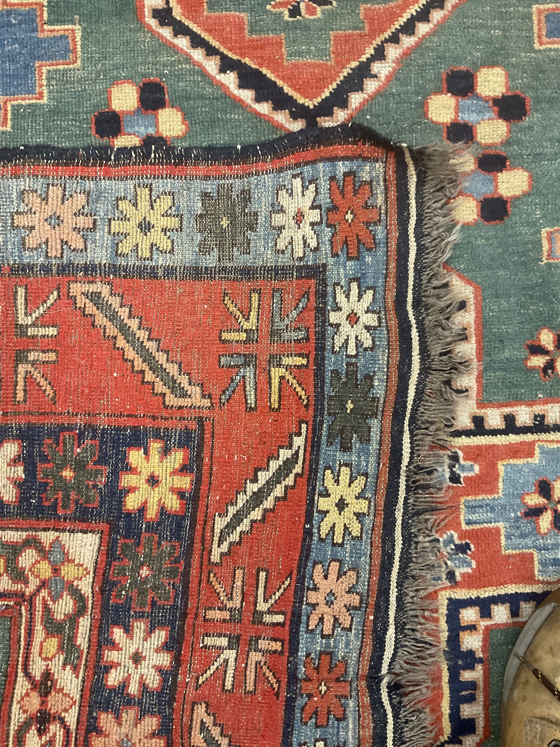 Caucasian turquoise ground rug, two medallions on a field decorated with stylised animal and geometric motifs, the guarded border decorated with further geometric motifs